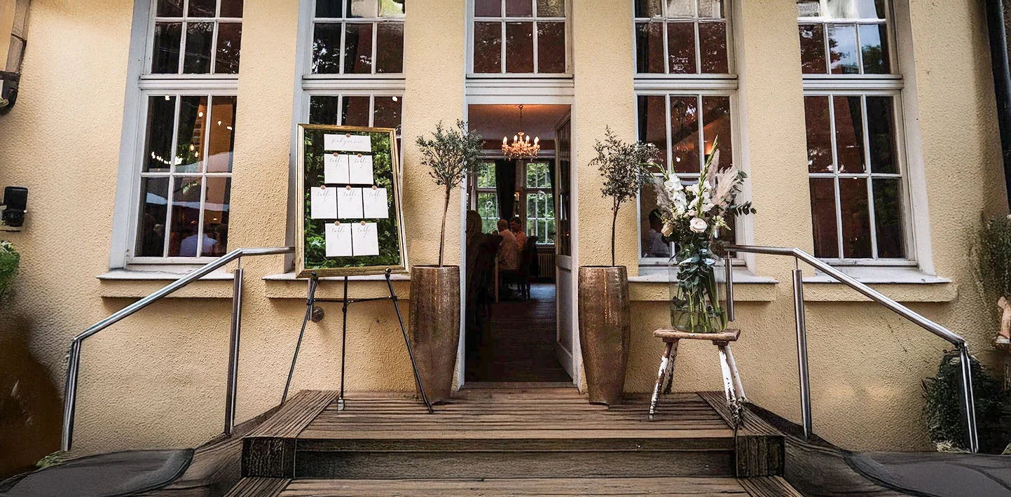 Eingangsbereich der Villa Mediterrane in Bielefeld mit geöffneter Tür und Blumendekoration